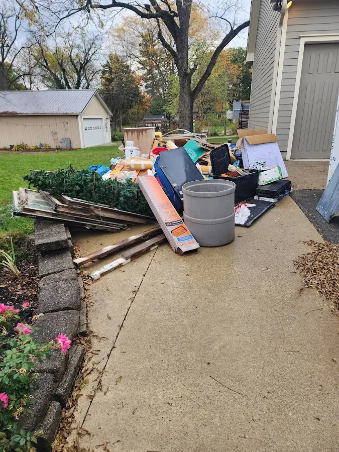 Dumpster being loaded with debris for Estate Cleanout Dumpster Rental in Jena